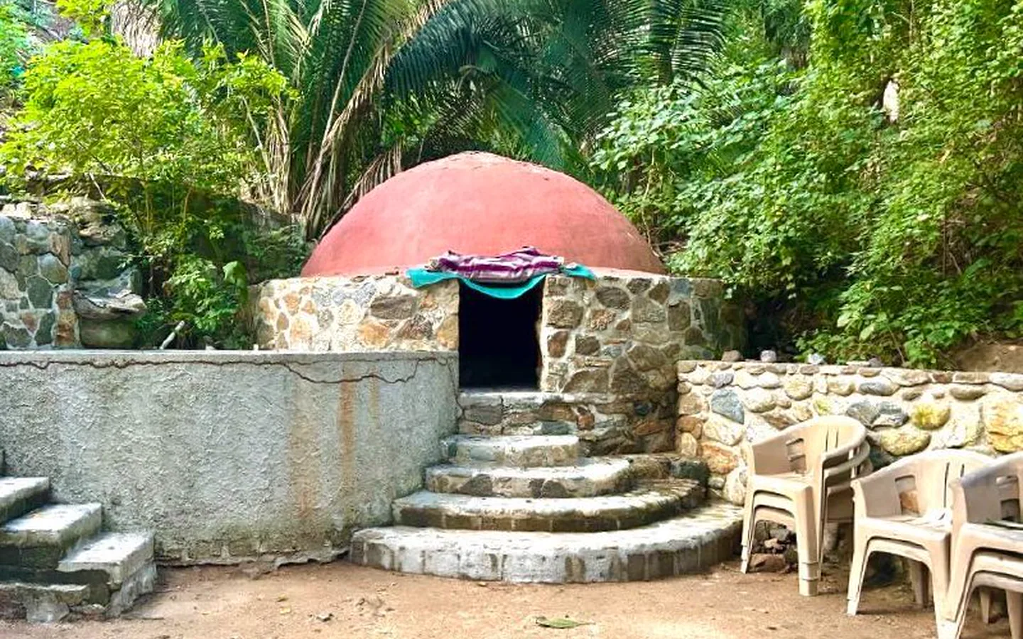 temazcal-card-popup-1440x900-perf-v1.webp A traditional red-domed temazcal surrounded by tropical greenery